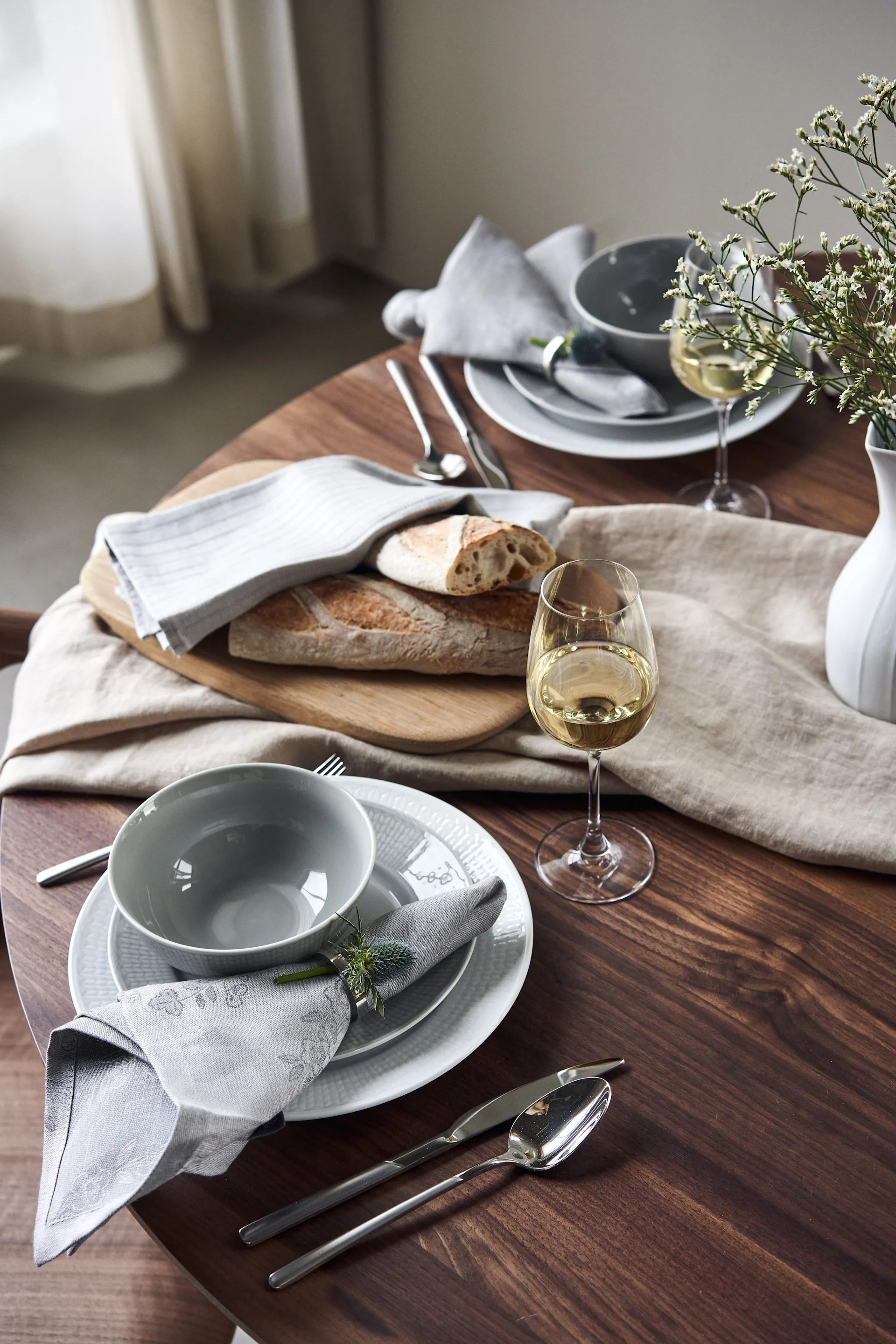 Set de table Swedish Grace avec bol et assiettes en nuances froides de gris et de blanc. 