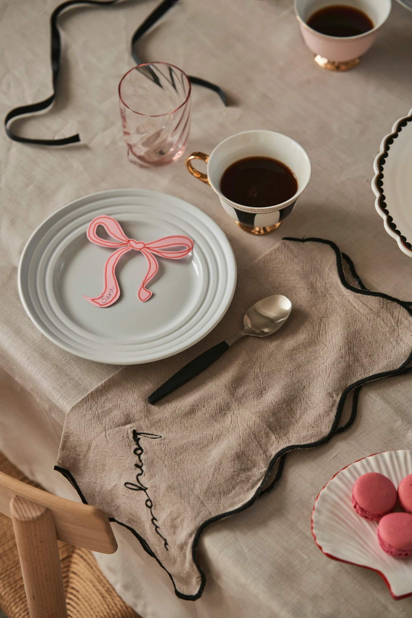 Dressez la table pour fêter la Galentine avec vos amies préférées. Vous voyez ici des serviettes en lin de Byon et des tasses à thé rayées noir et blanc de Hilke Collection. 