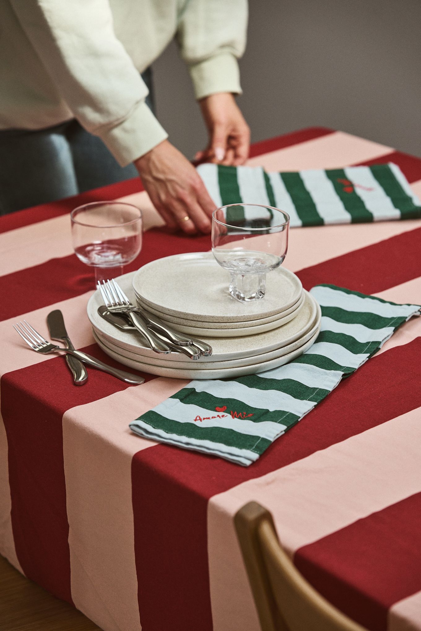 Le rouge cerise associé au rose poudré est l'une des plus grandes tendances de 2025. Ici, vous voyez la nappe Byon avec des rayures rouges et roses. 