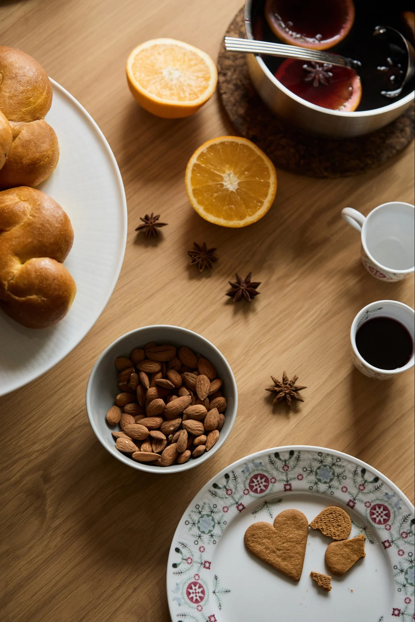 Une table remplie de délices pour une fête de Noël : petits pains au safran, glögg et amandes.