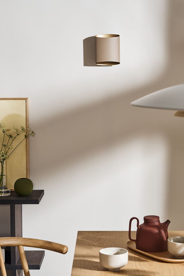 Superposez vos idées d'éclairage de salle à manger, comme l'applique Sinne de Belid, vue ici en beige sur le mur d'une salle à manger.