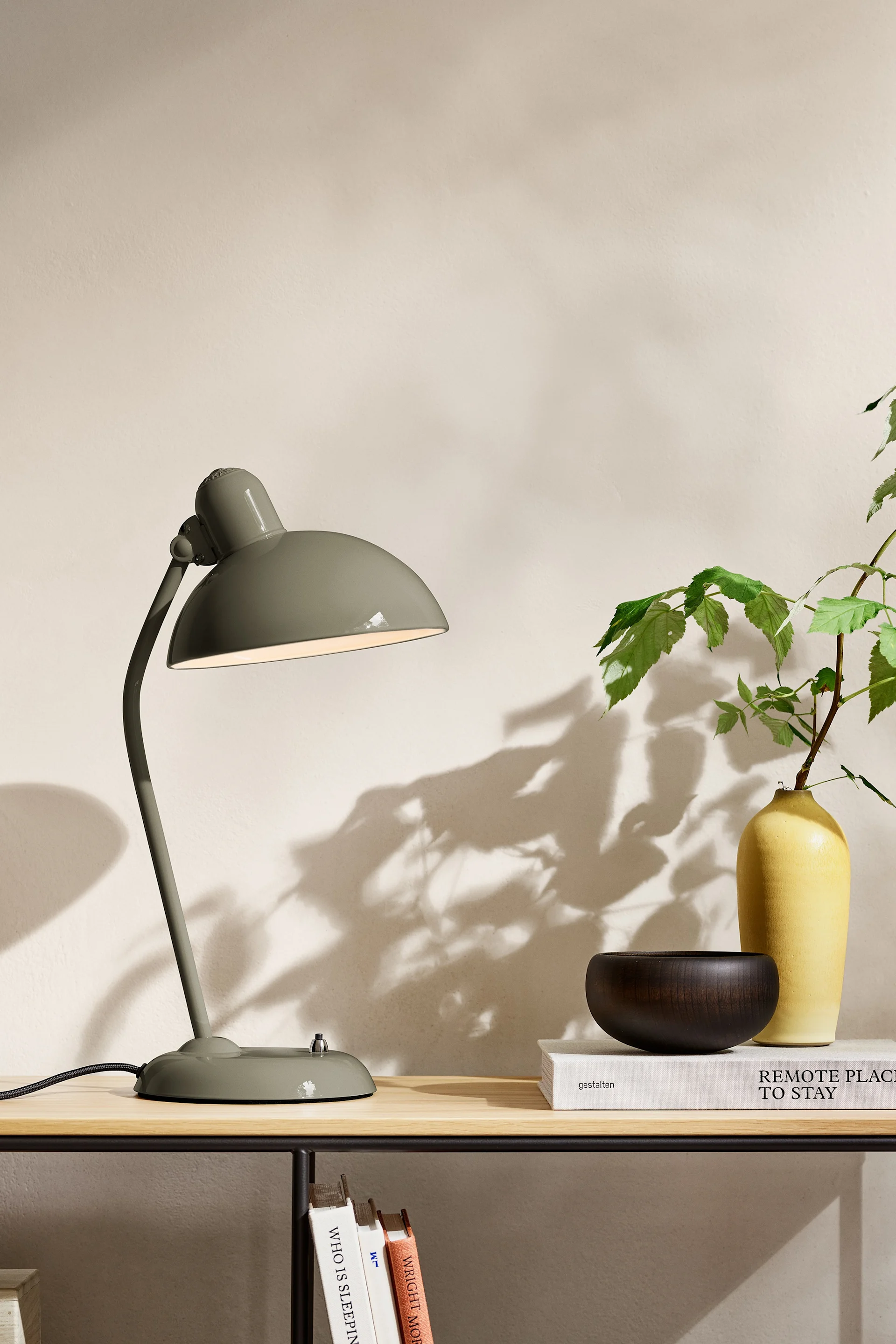 Les tendances en matière de couleurs d'intérieur pour 2025 comprennent une nuance naturelle de vert olive. Ici, la lampe Kaiser Idell de Fritz Hansen est posée sur un buffet. 