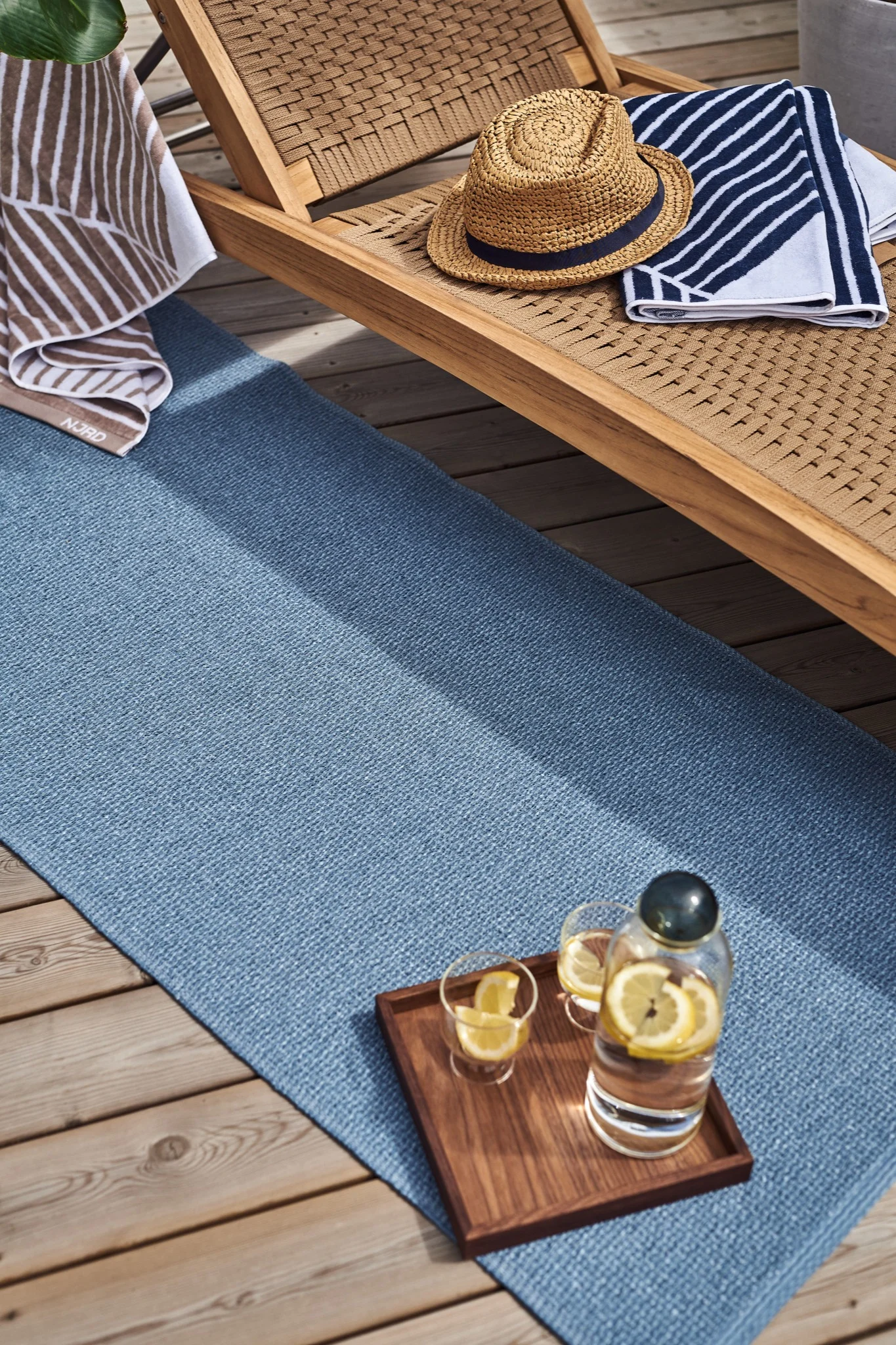 Ici, vous voyez le tapis en plastique bleu, Mellow, de Scandi Living. C'est l'accessoire idéal pour l'été, à placer sur la terrasse, afin de créer une atmosphère chaleureuse dans votre espace extérieur.