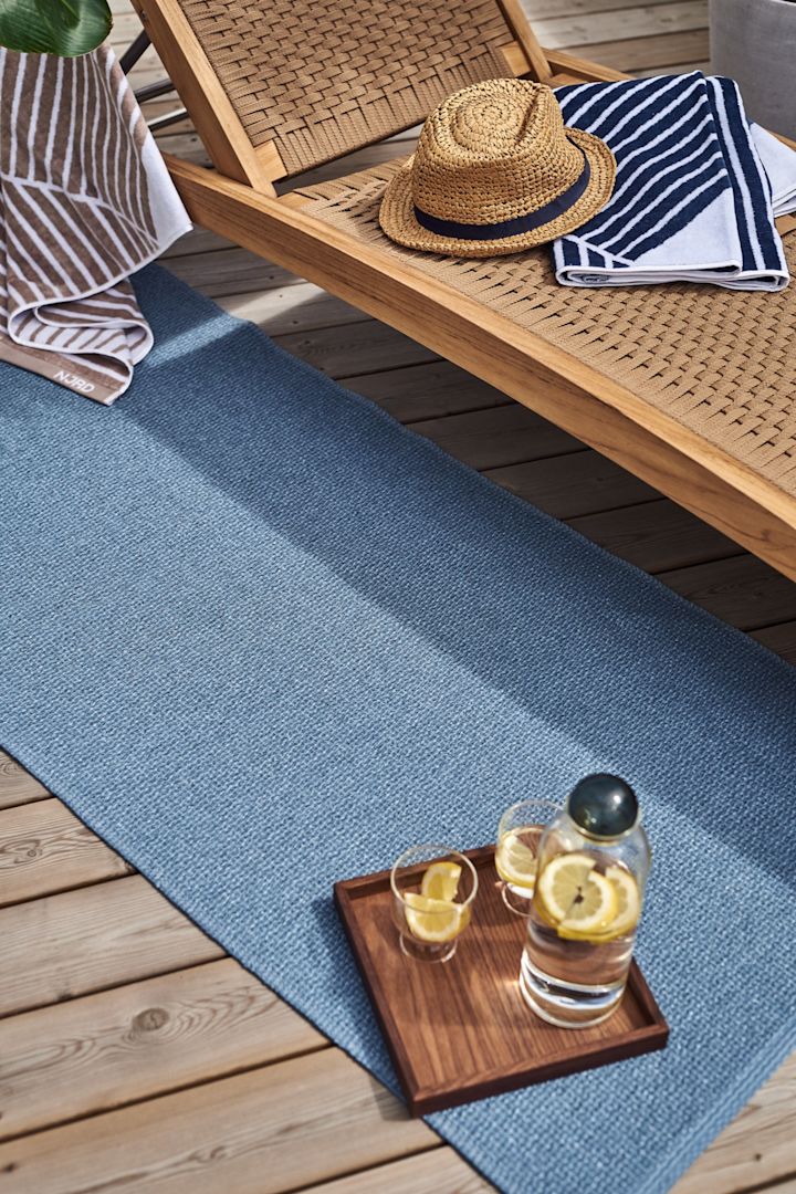 Ici, vous voyez le tapis en plastique bleu, Mellow, de Scandi Living. C'est l'accessoire idéal pour l'été, à placer sur la terrasse, afin de créer une atmosphère chaleureuse dans votre espace extérieur.