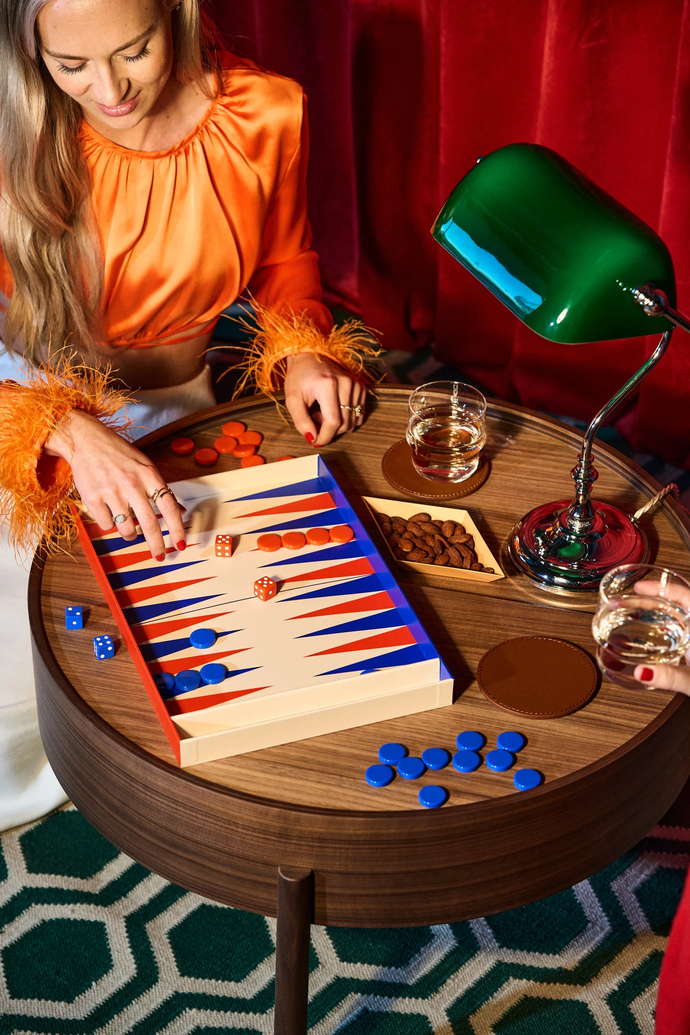 Comment organiser une fête avec des jeux traditionnels comme le backgammon : ici, vous le voyez dans un cadre rétro avec une lampe verte traditionnelle de Fritz Hansen.