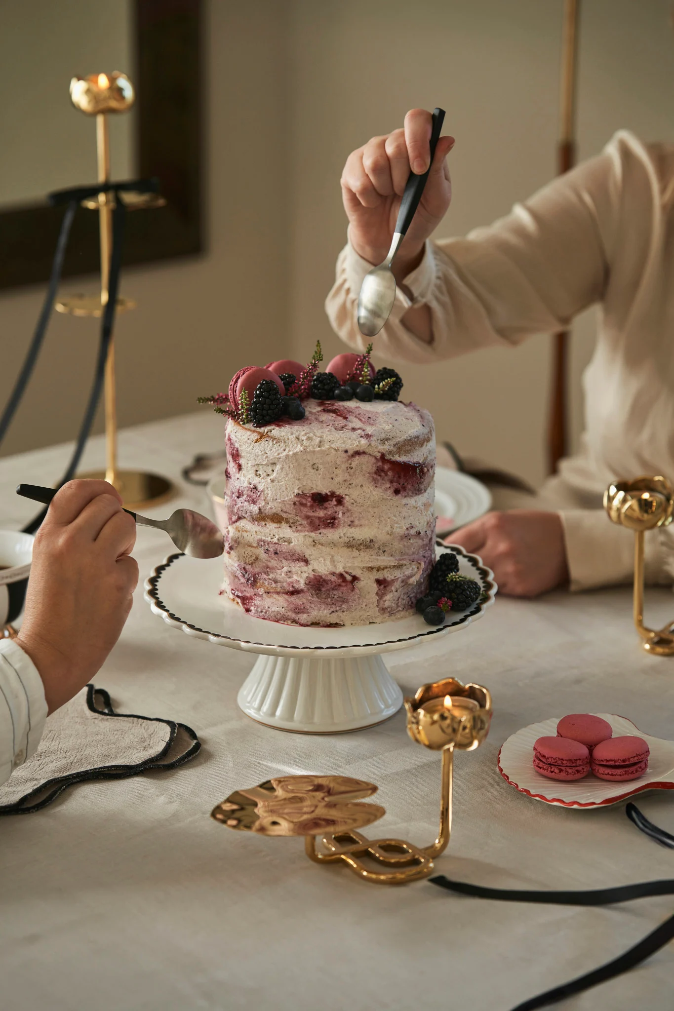De nombreux produits Hilke sont présentés dans de jolis emballages cadeaux, comme ici sur une assiette Lines de NJRD, à côté de laquelle se trouve la tasse Strisce de Hilke, de couleur rose.