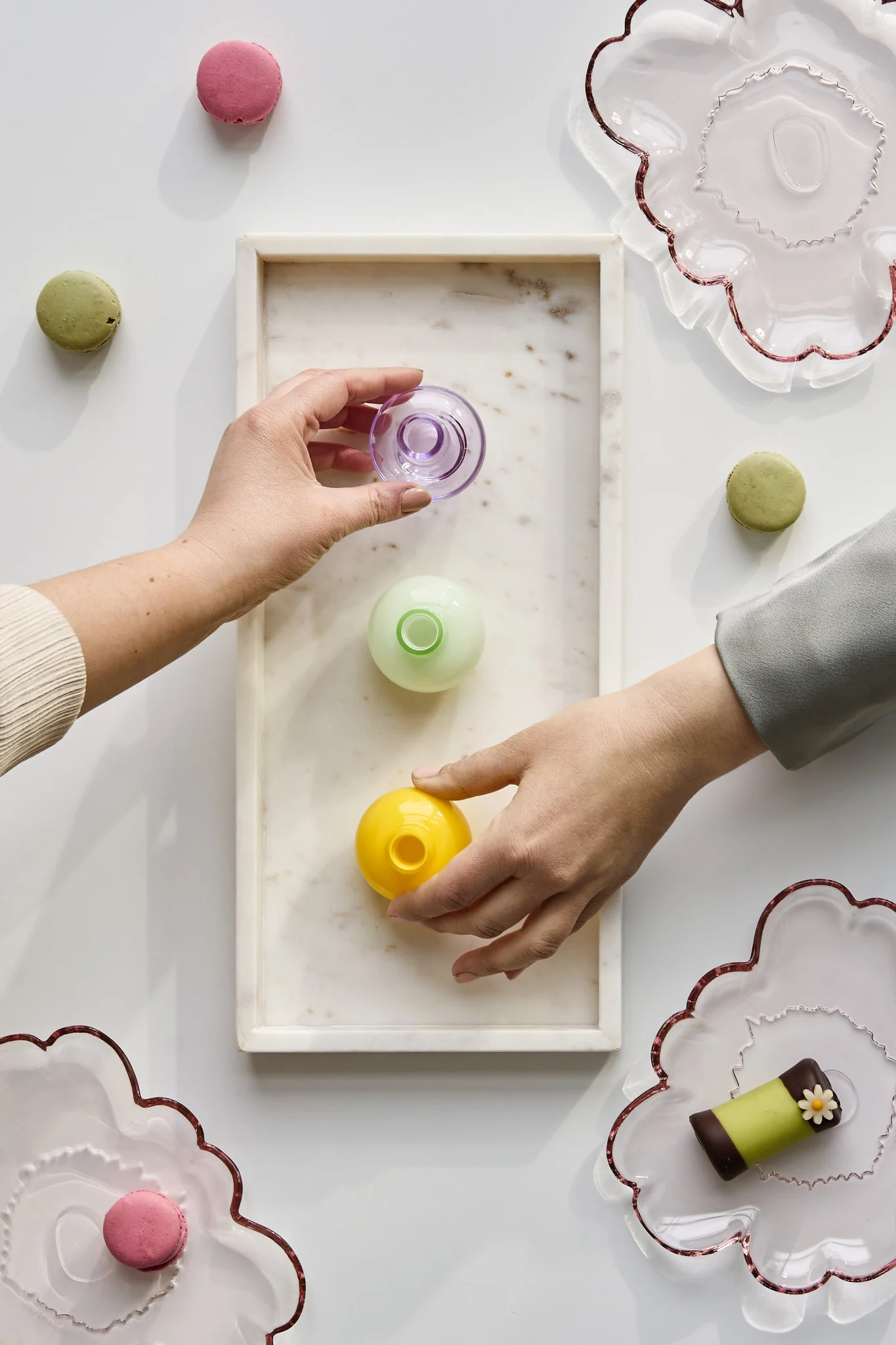 Des mains saisissent des mini vases de différentes couleurs à emporter en souvenir de la fête. Découvrez comment organiser une fête avec une ambiance inoubliable.