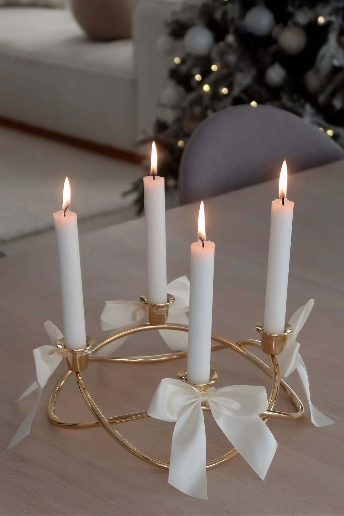 Le bougeoir Season doré et décoré de rubans de Georg Jensen est posé sur une table.