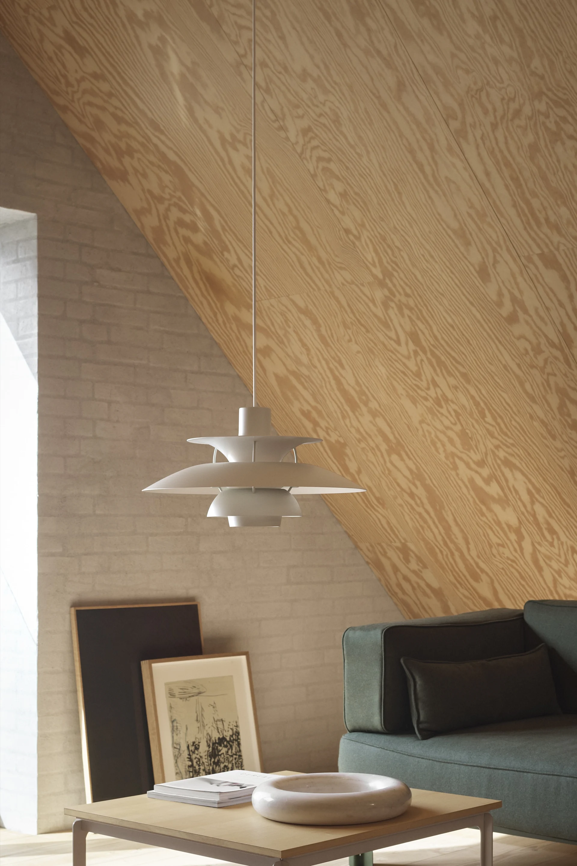 Lampes scandinaves : la mini suspension PH 5 de Louis Poulsen est suspendue dans un salon scandinave.