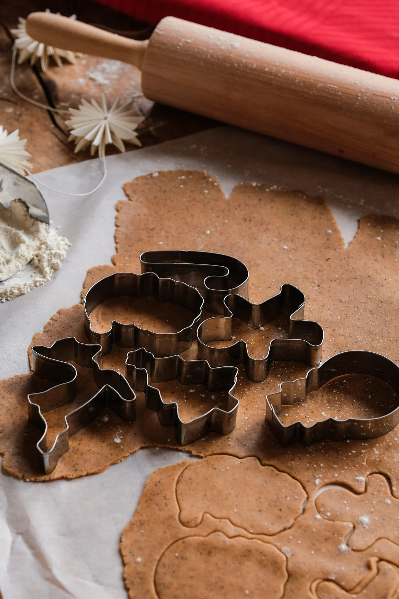Biscuits de Noël : différentes formes de pain d'épices sont disposées sur une pâte étalée.
