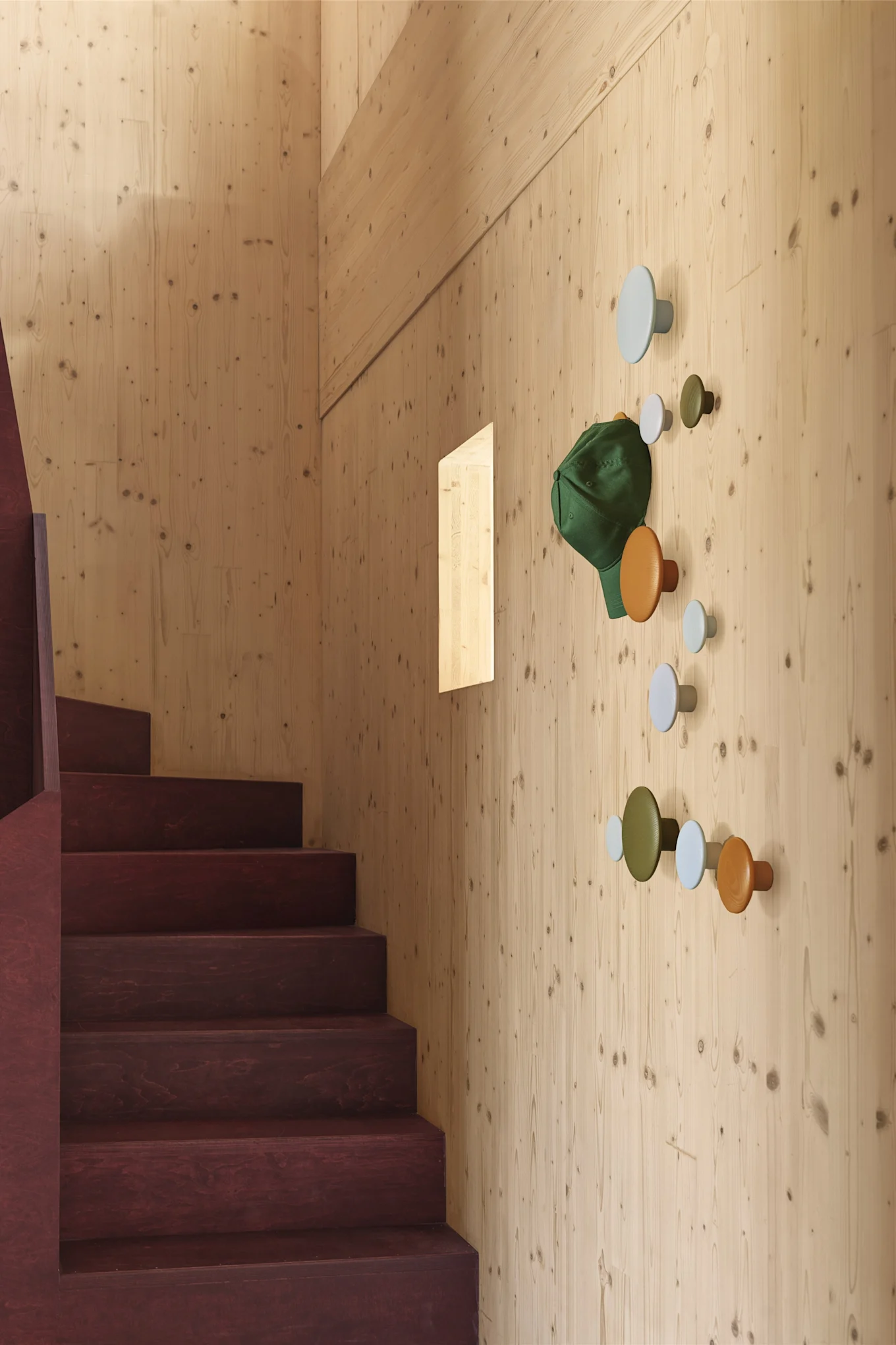 Organisez votre intérieur en utilisant les petits espaces et les murs de votre maison. Ici, les crochets The Dots de Muuto ont été utilisés dans une cage d'escalier pour créer un espace de rangement pour les vêtements d'extérieur et les sacs.