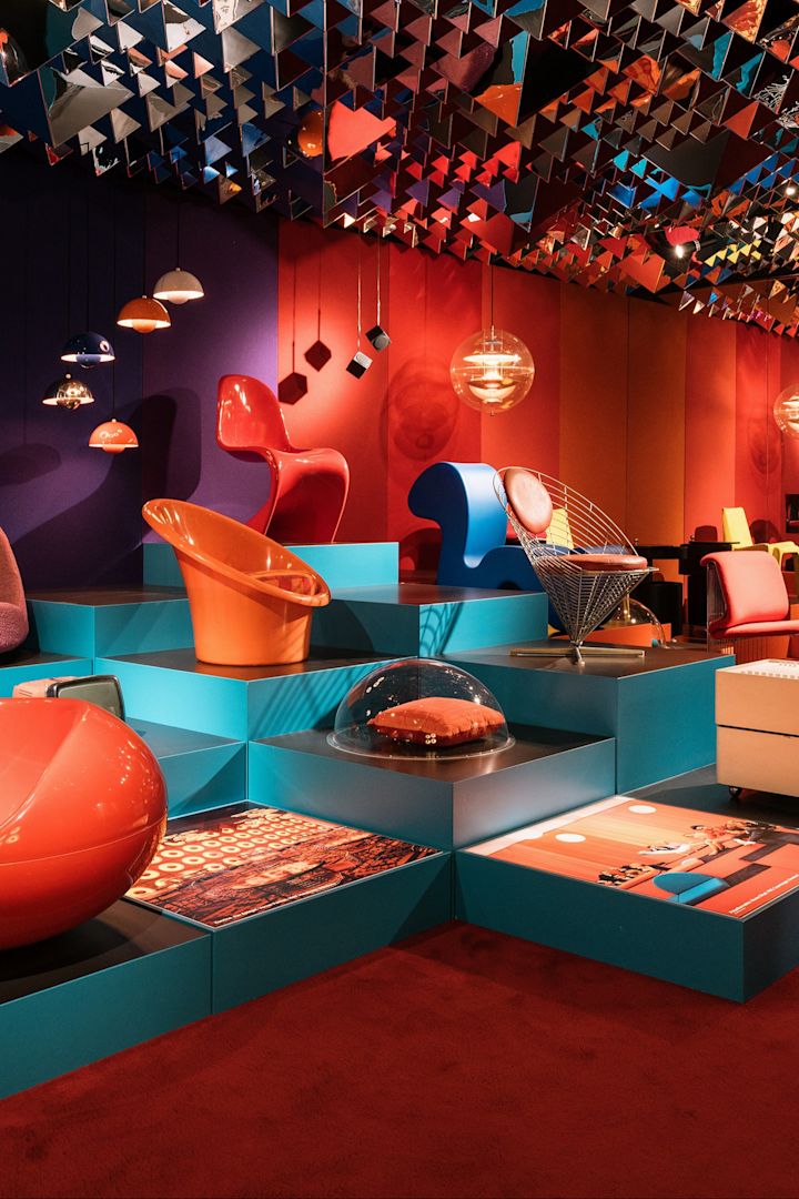 Le musée du design de Copenhague est un endroit idéal pour découvrir les classiques du design danois. Ici, vous voyez une pièce rouge et bleue avec des lampes et des chaises qui s'entrechoquent.