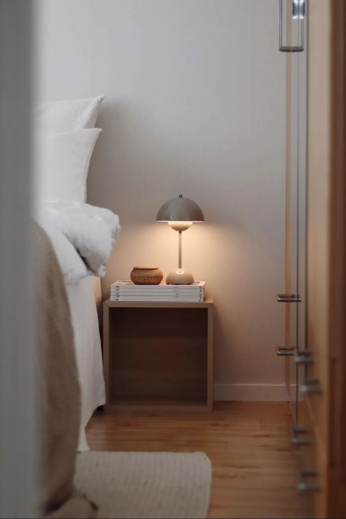 La lampe rechargeable Flowerpot de &tradition est posée à côté d'un lit et éclaire la pièce.