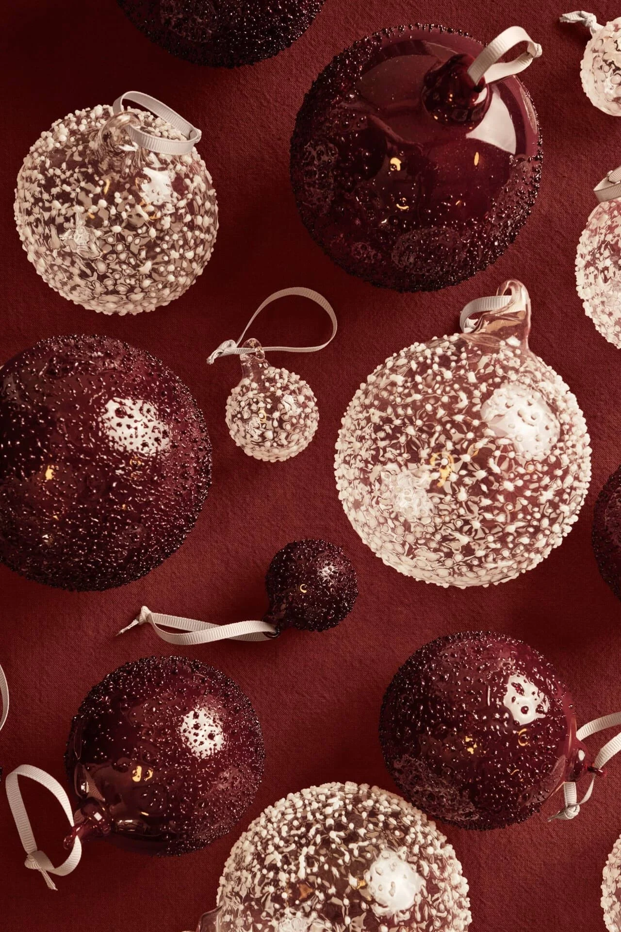 Les pendentifs décoratifs Candy de Pluto Design font partie des décorations de Noël 2025 et sont présentés ici sur une table.