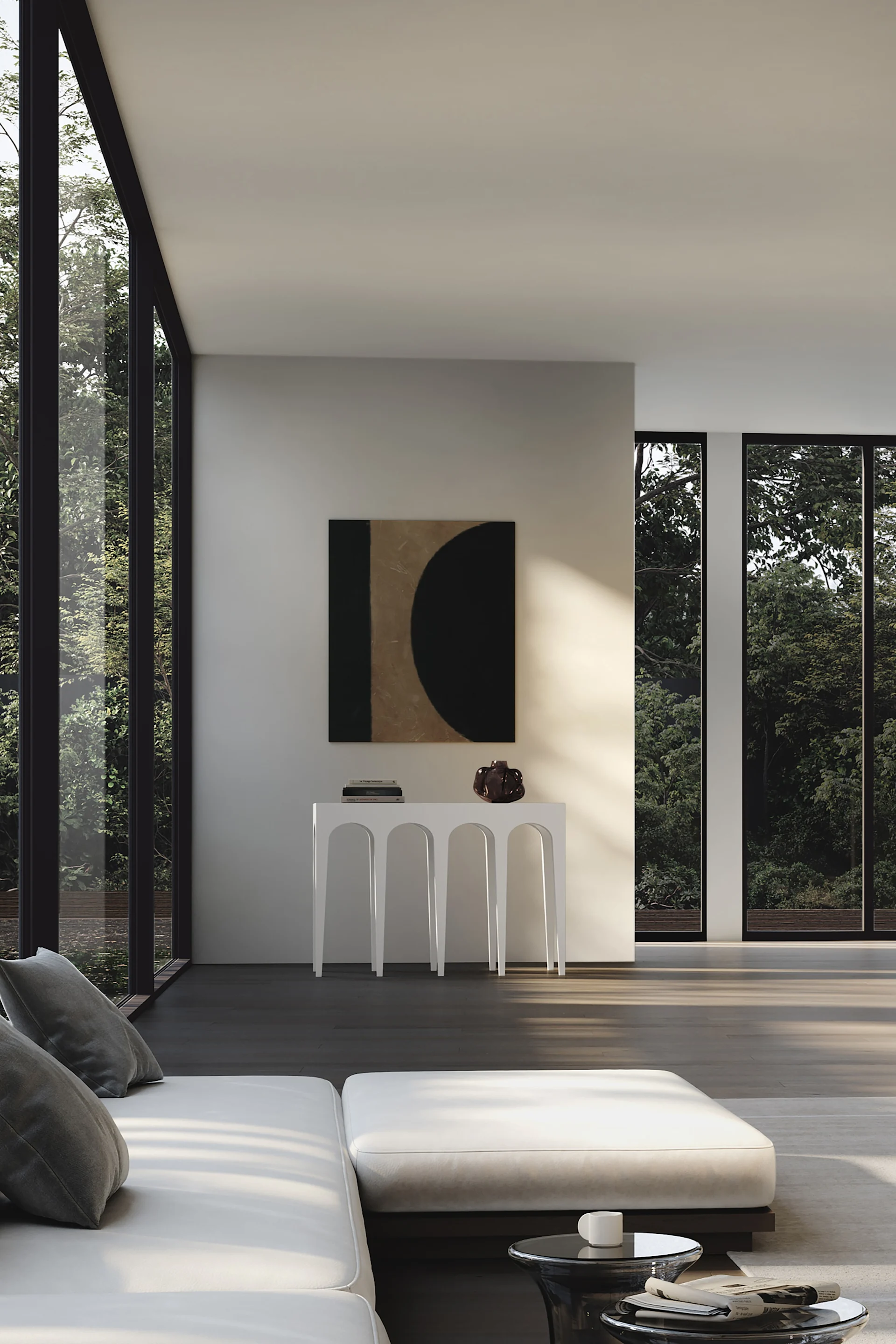 Un salon moderne avec un canapé blanc, une console placée sous un tableau abstrait et de grandes fenêtres donnant sur des arbres verdoyants.