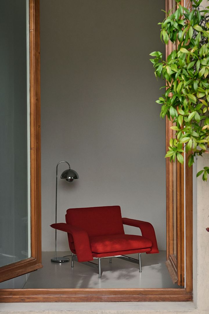 Les années 60 et 70 reviennent en force dans les tendances d'intérieur de l'automne 2025. Ici, la chaise longue rouge Meantime de &tradition se trouve dans une fenêtre ouverte.