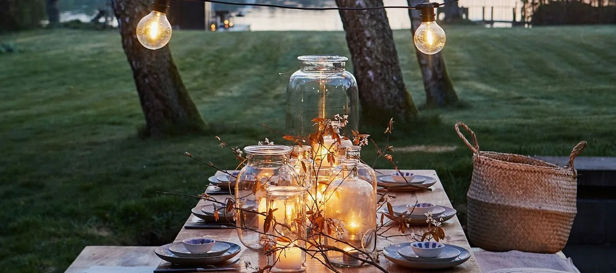 Créez une ambiance chaleureuse pour votre garden-party et décorez la table avec de nombreuses lanternes et photophores pour l'extérieur !