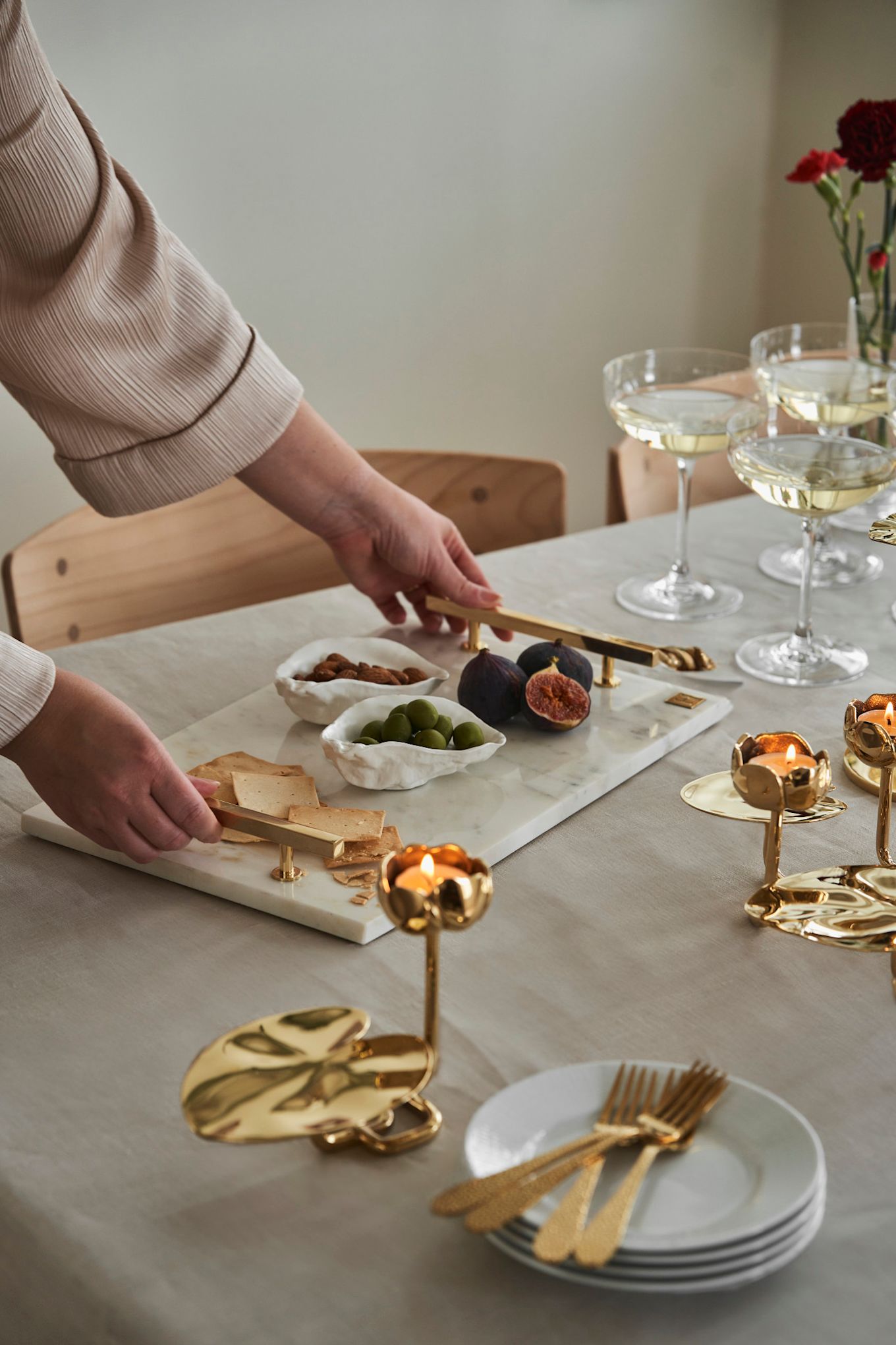 Offrez à vos amies un goûter à l'occasion de la fête de Galentine. Ici, un plateau en marbre de Hilke Collection côtoie des bougeoirs dorés en forme de nénuphar. 