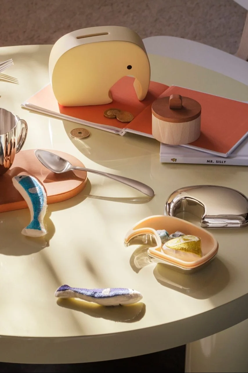 L'argent aussi est souvent un cadeau apprécié pour la baby shower. Emballez-le joliment dans la tirelire jaune Miniphant de Georg Jensen, qui est pratique et décorative.