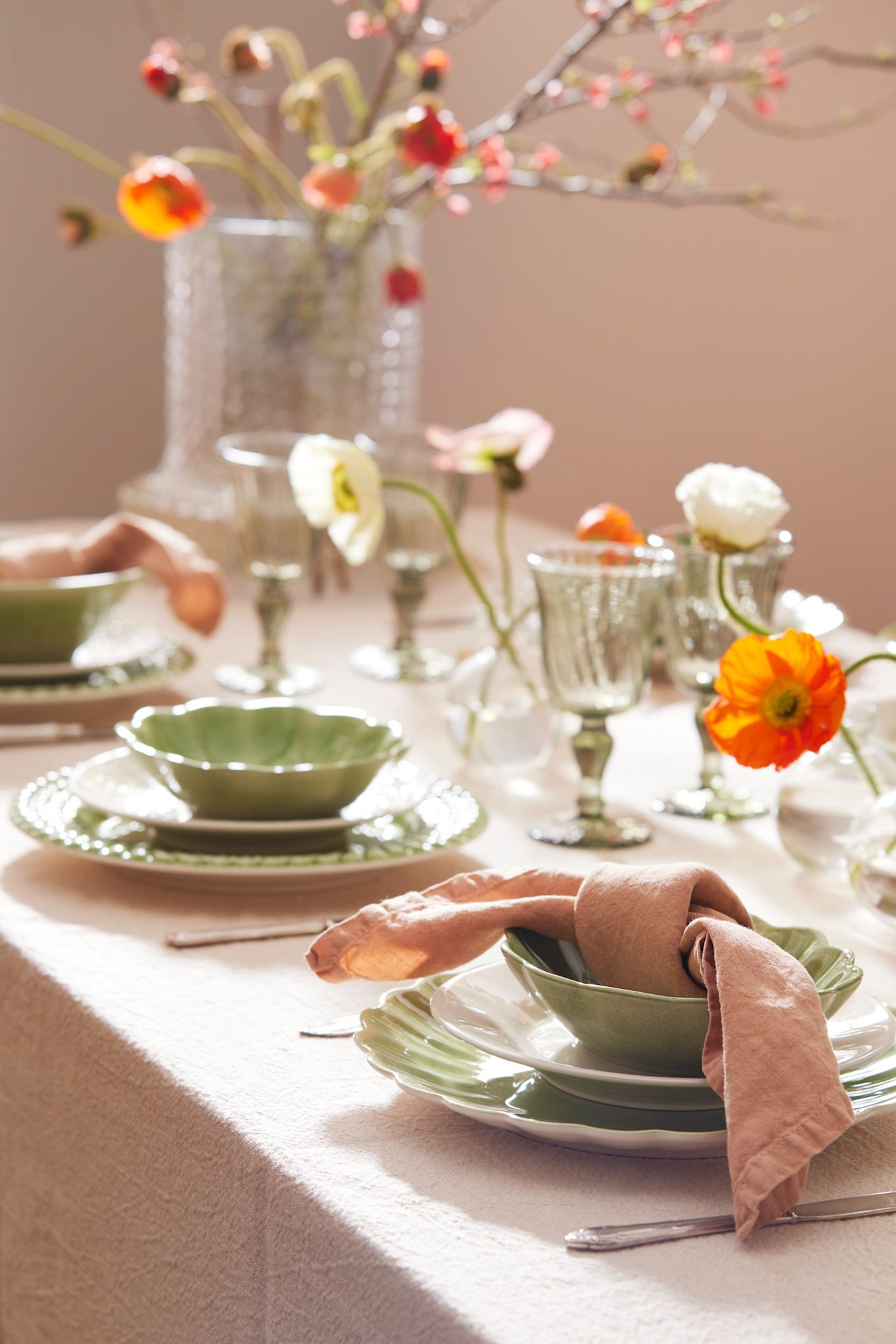 Voici une idée de table de Pâques verte de Mateus avec des assiettes vertes et des serviettes de table en lin rose. 