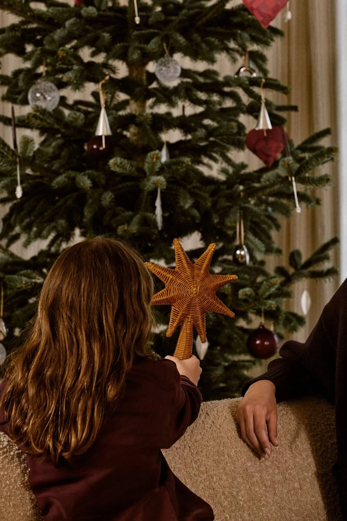 La bougie de l'Avent Holmegaard est posée sur une boîte festive, accompagnée de biscuits.