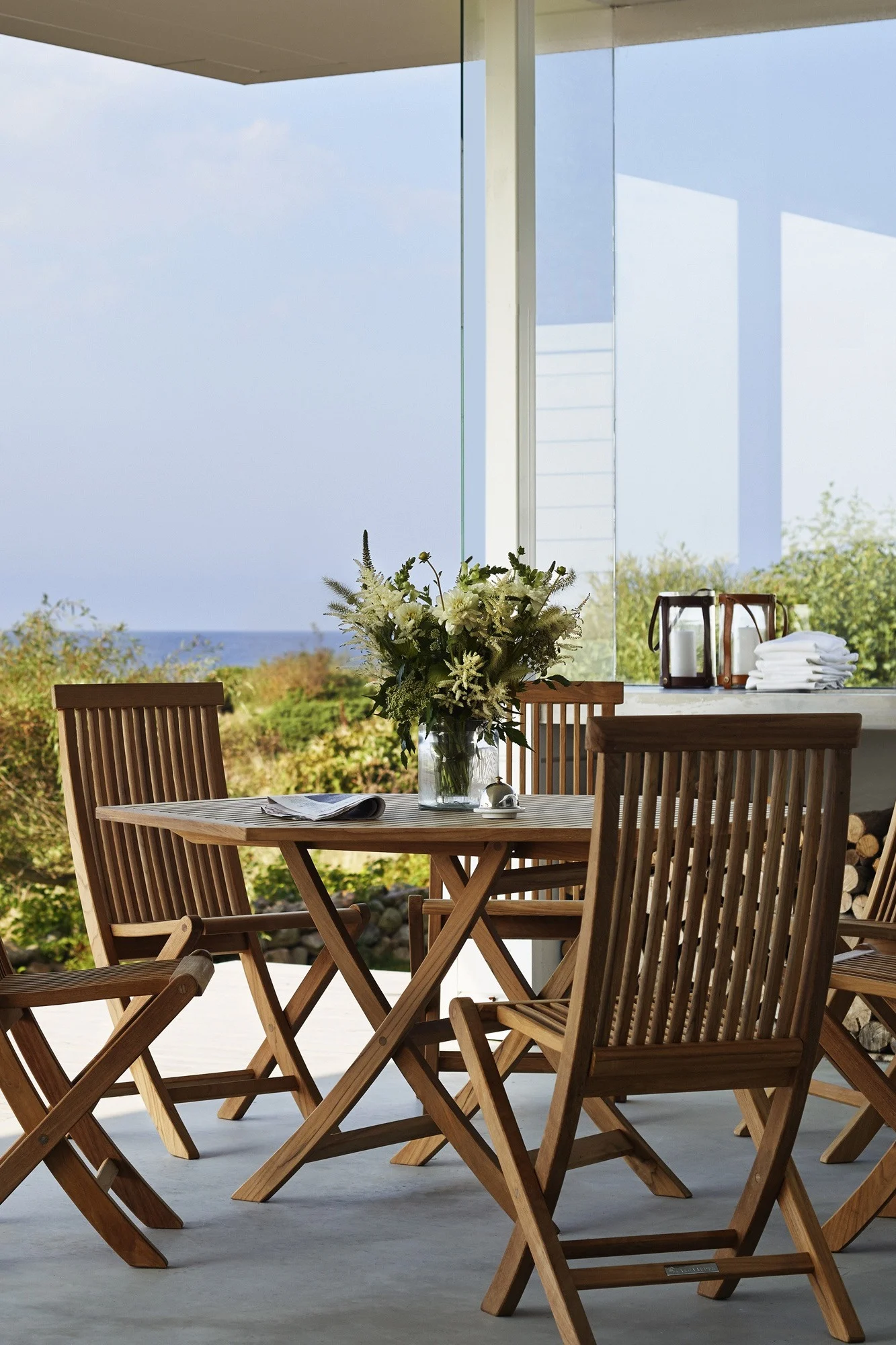 Le teck est une tendance parmi les meubles de jardin de 2025. Vous voyez ici la table et les chaises de la collection Viken de Skargaarden posées sur une terrasse.