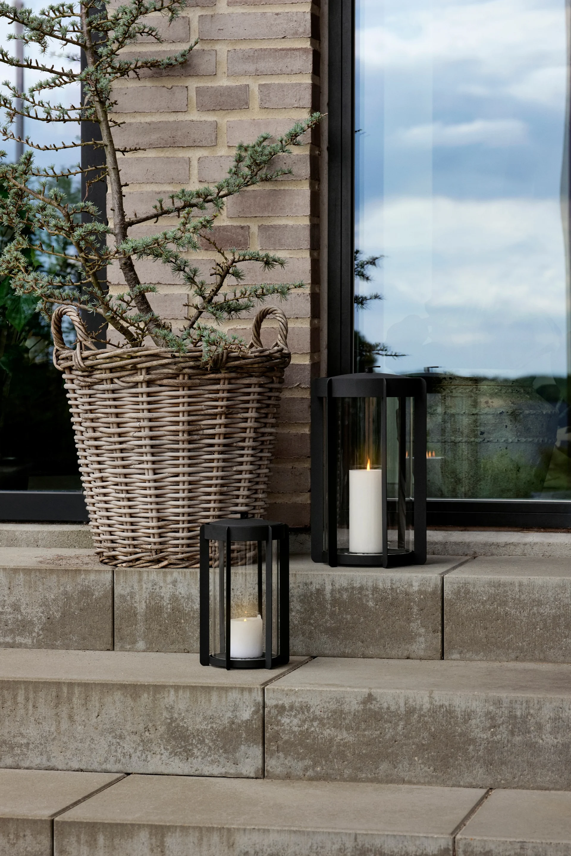 Embellissez votre escalier extérieur avec des lanternes et des photophores pour l'extérieur, par exemple avec la lanterne Light'In de Audo Copenhagen.