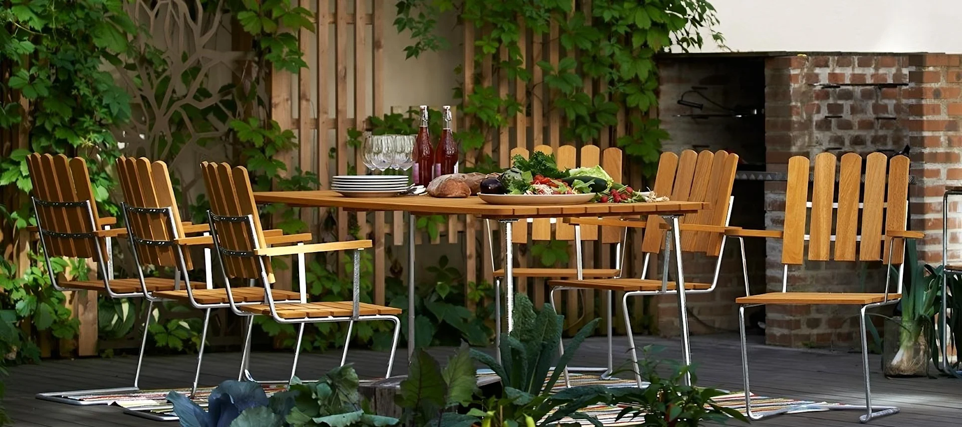 Une marque importante pour les tendances des meubles de jardin en 2025 : Grythyttan. On peut voir ici la série classique, composée d'une grande table et de chaises sur une terrasse.