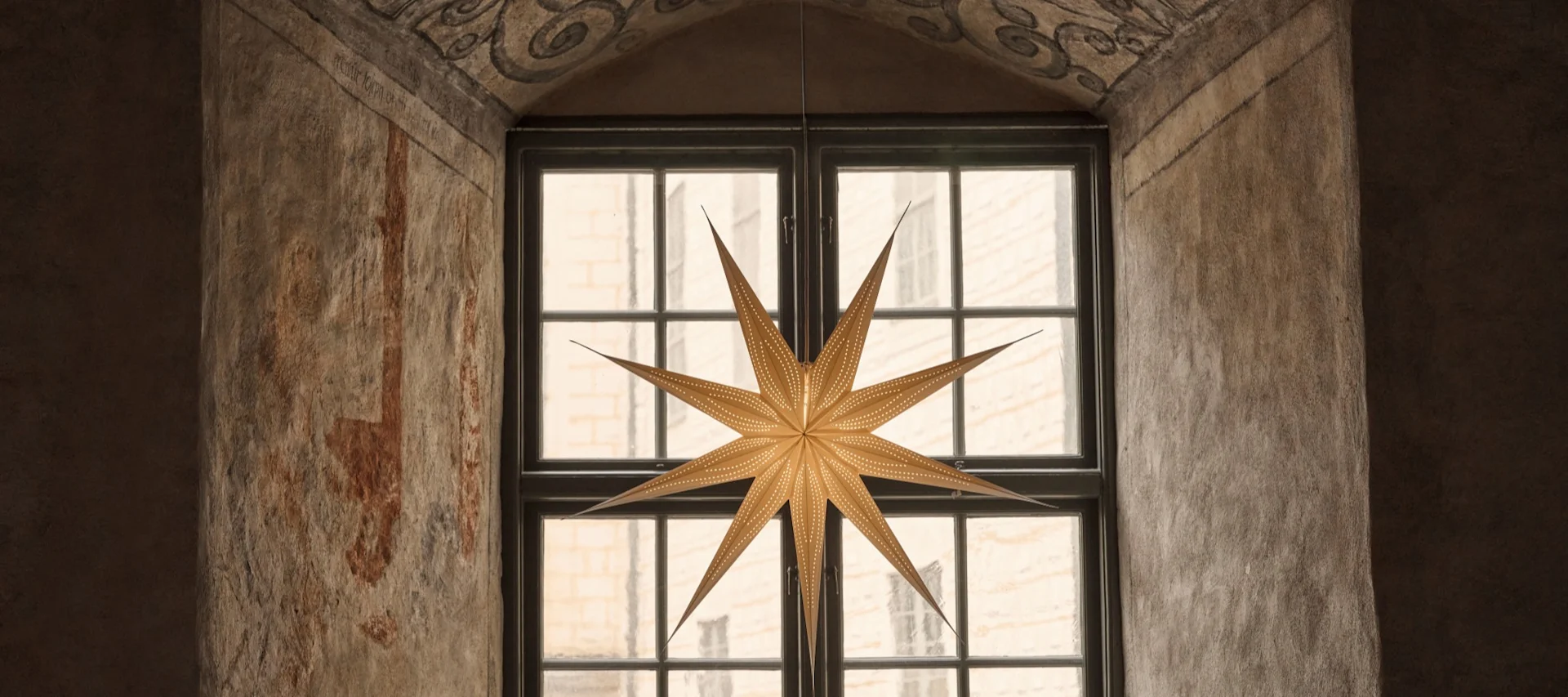 Deux lanternes en papier rouge en forme d'étoile de Watt & Veke suspendues dans un salon.