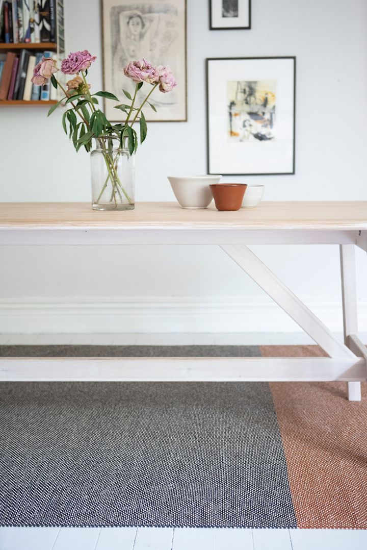 Tapis pour l'entrée : le tapis Moor de Brita Sweden est placé sous une table, au mur de nombreux tableaux.