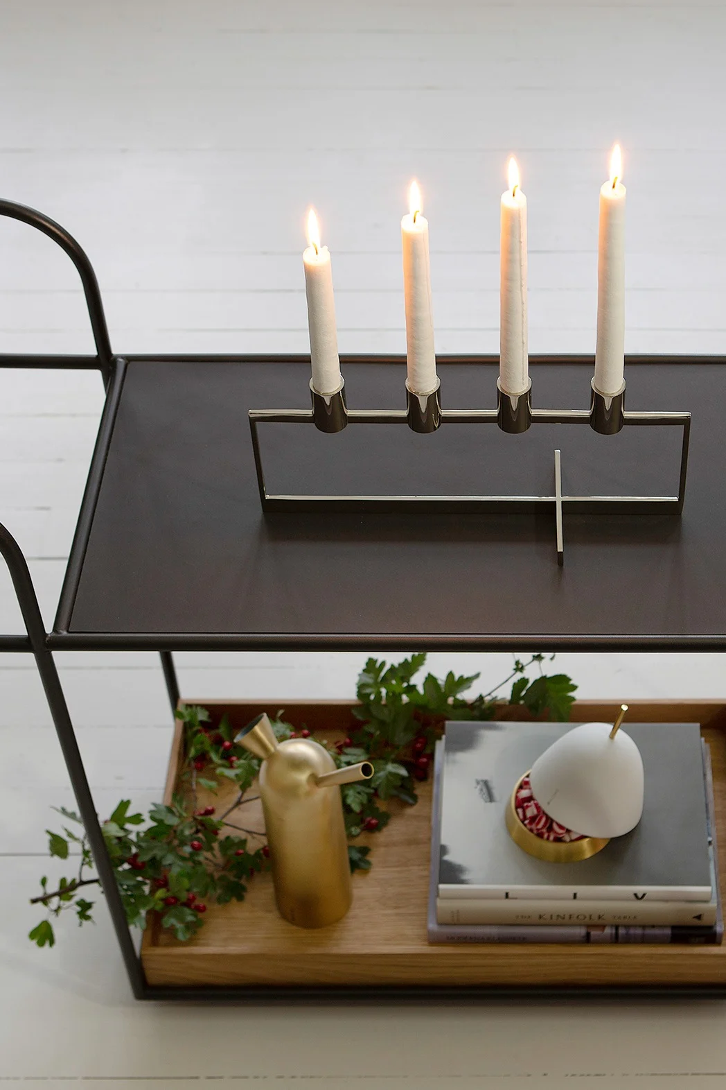 Le bougeoir Anno Domini de Klong est posé sur un chariot de service, dont l'étage inférieur est décoré dans l'esprit de Noël.