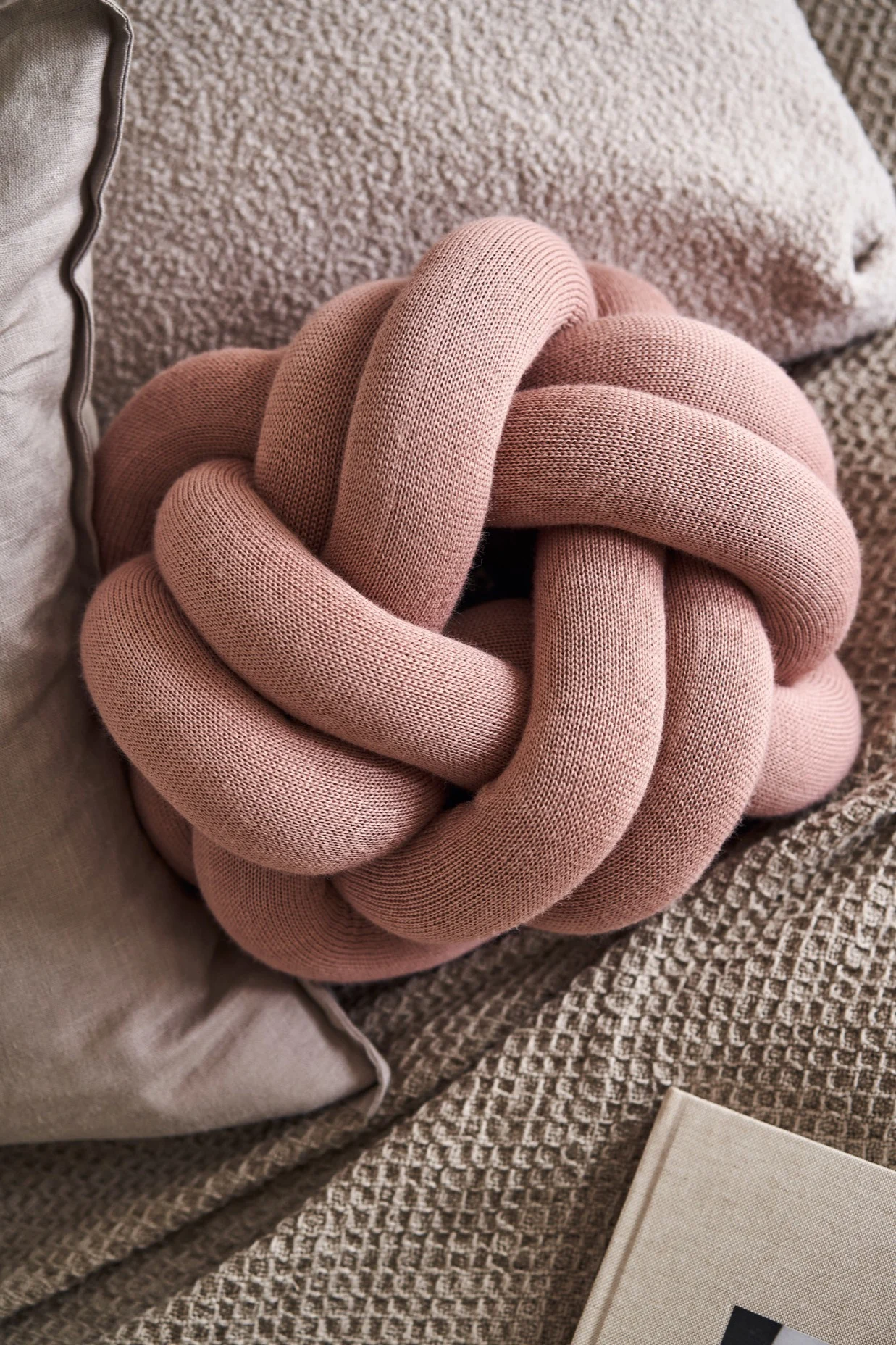 Ici, vous voyez le coussin Knot de Design House Stockholm dans un rose poussiéreux. 