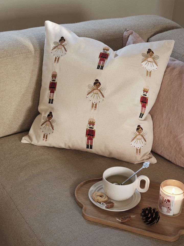 La housse de coussin brodée de Broste Copenhagen, présentée ici sur un canapé, est l'une des tendances en matière de décorations de Noël pour 2025.