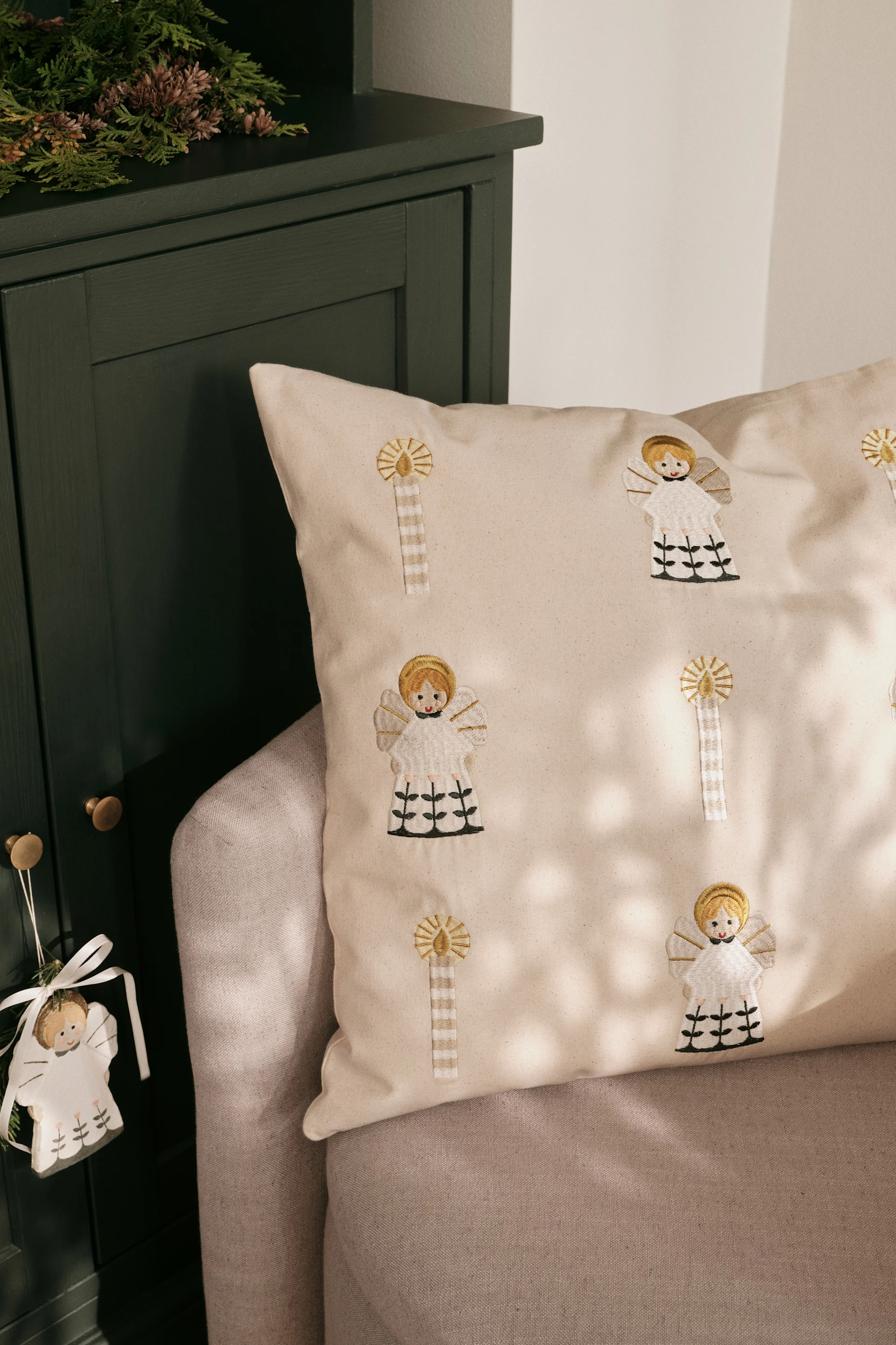 La housse de coussin brodée de Broste Copenhagen, présentée ici sur un canapé, est l'une des tendances en matière de décorations de Noël pour 2025.
