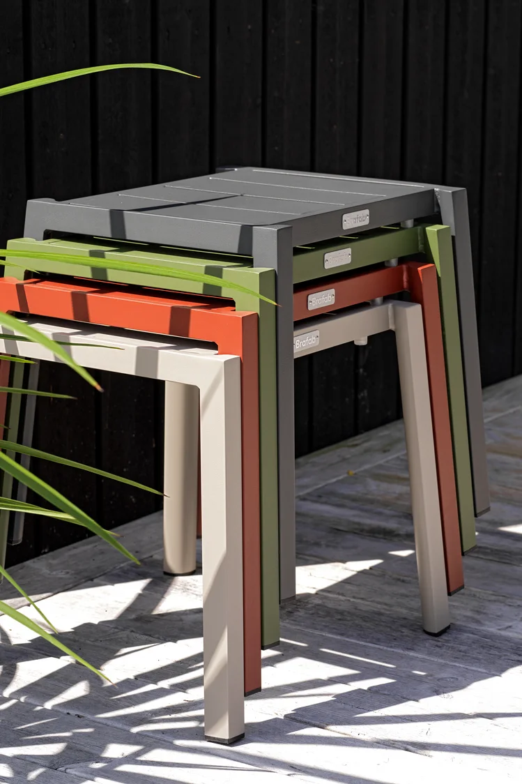 Les meubles multifonctionnels font également partie des tendances en matière de meubles de jardin en 2025. Les tabourets de la collection Delia de Brafab, ici empilés les uns sur les autres en quatre couleurs différentes, sont peu encombrants et peuvent être utilisés de différentes manières.