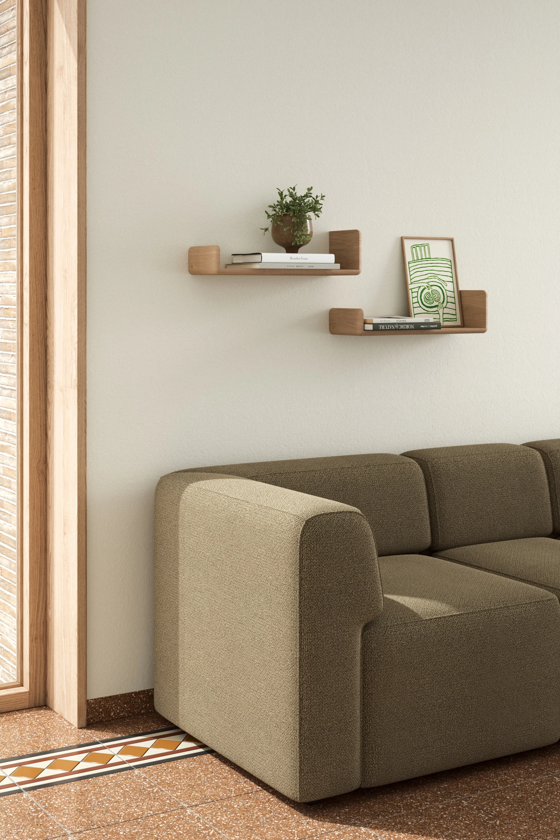 Un salon chaleureux avec un canapé sectionnel beige, des étagères murales en bois avec des livres et une plante, et un sol carrelé à motifs.