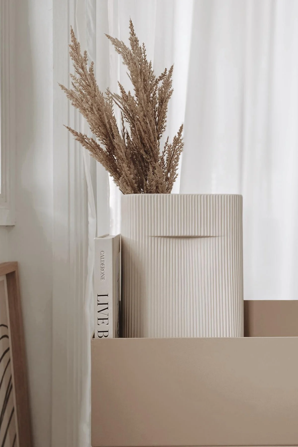LE style d'habitation Lagom est également synonyme de couleurs discrètes. Dans une Plant box beige de Ferm Living, le vase Ridge de Muuto avec des fleurs séchées à l'intérieur se trouve dans la maison de @beige_and_co.