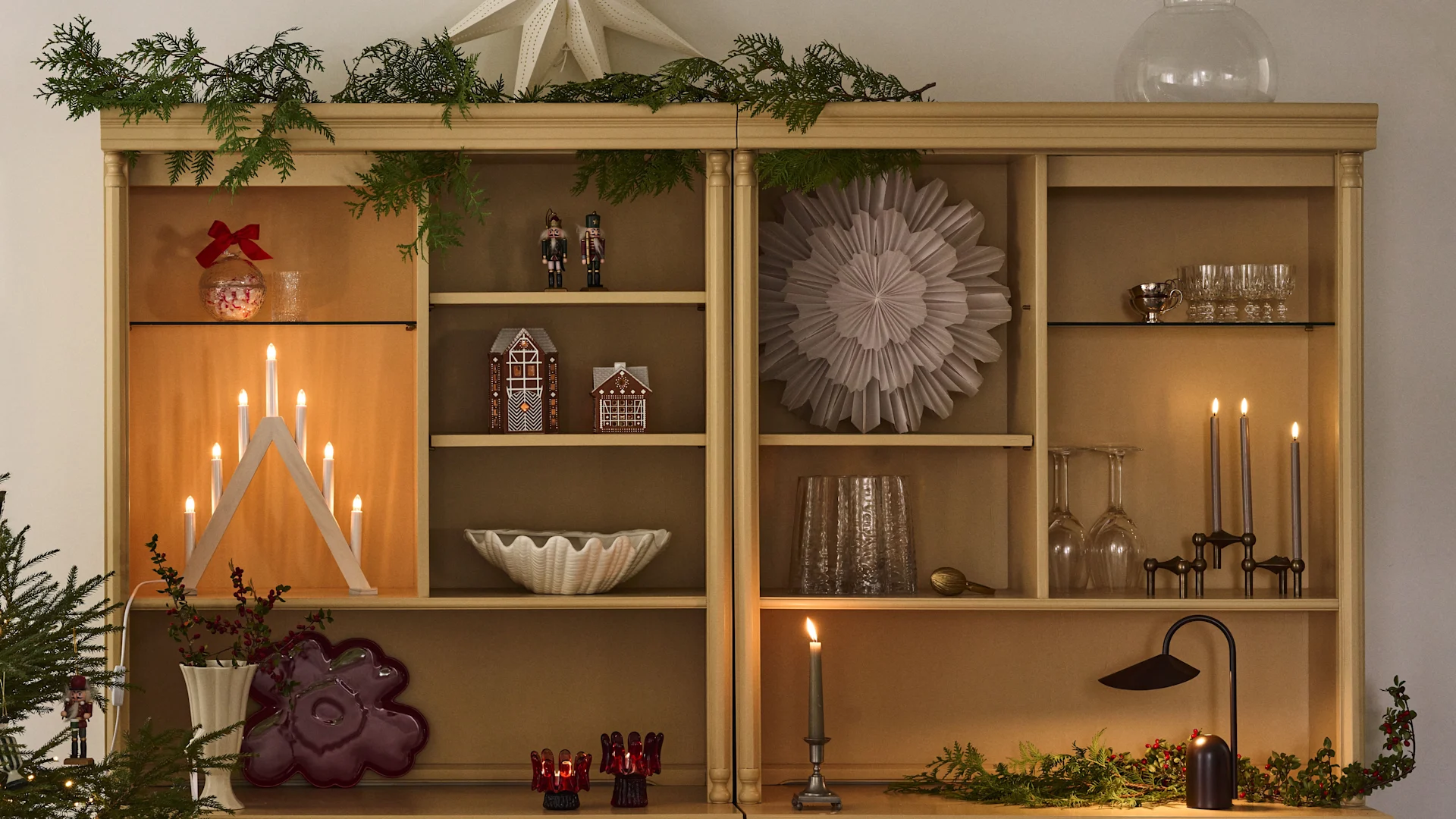 Une étagère décorée pour Noël avec des étoiles de Noël et des bougeoirs, parfaite pour se plonger dans l’ambiance du premier Avent.