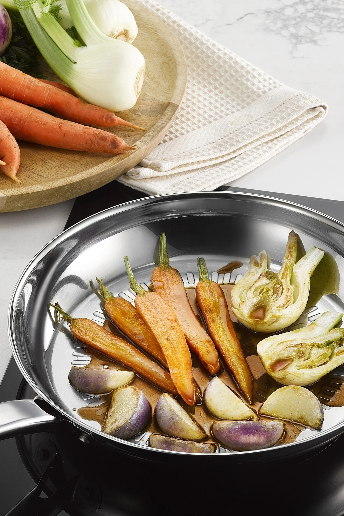 La poêle Intuition Techdome en acier inoxydable de Tefal permet de faire frire divers légumes.