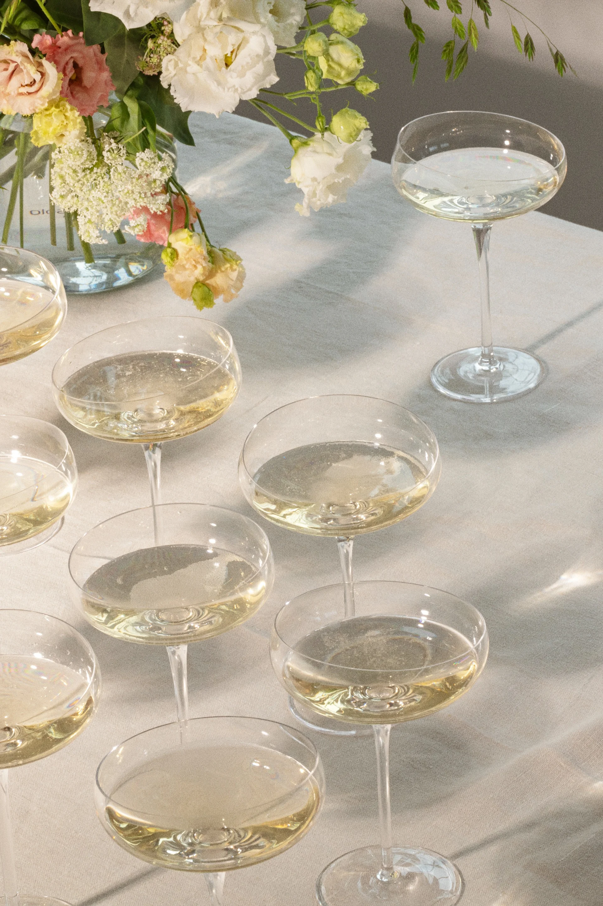 Coupes de champagne avec boissons pétillantes sur une table avec composition florale.