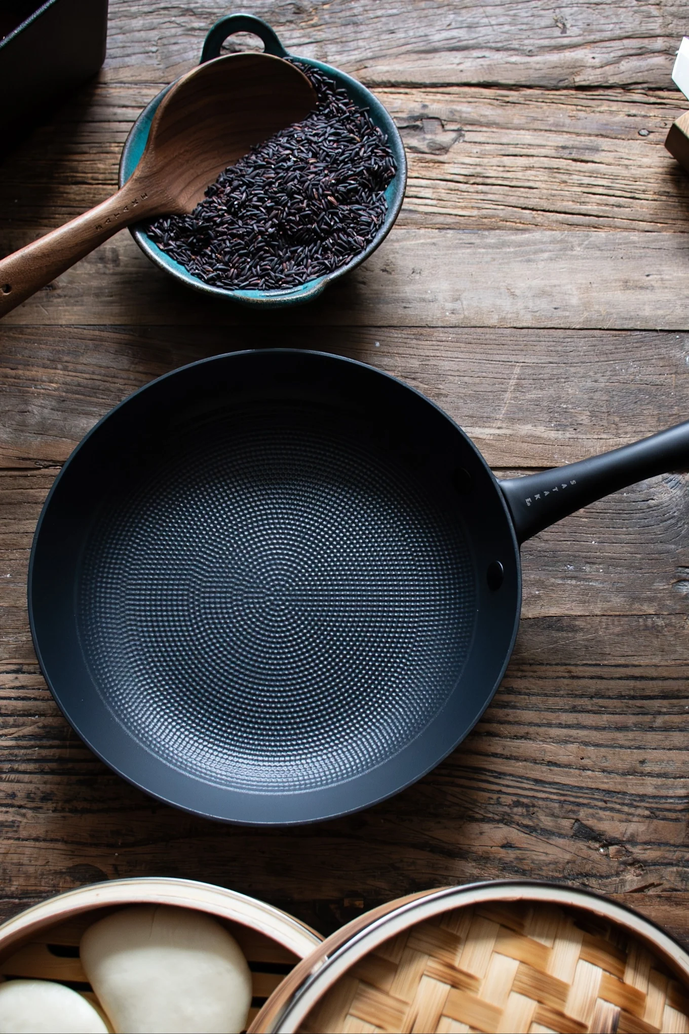 La poêle à frire de Satake est posée sur une table en bois sombre.