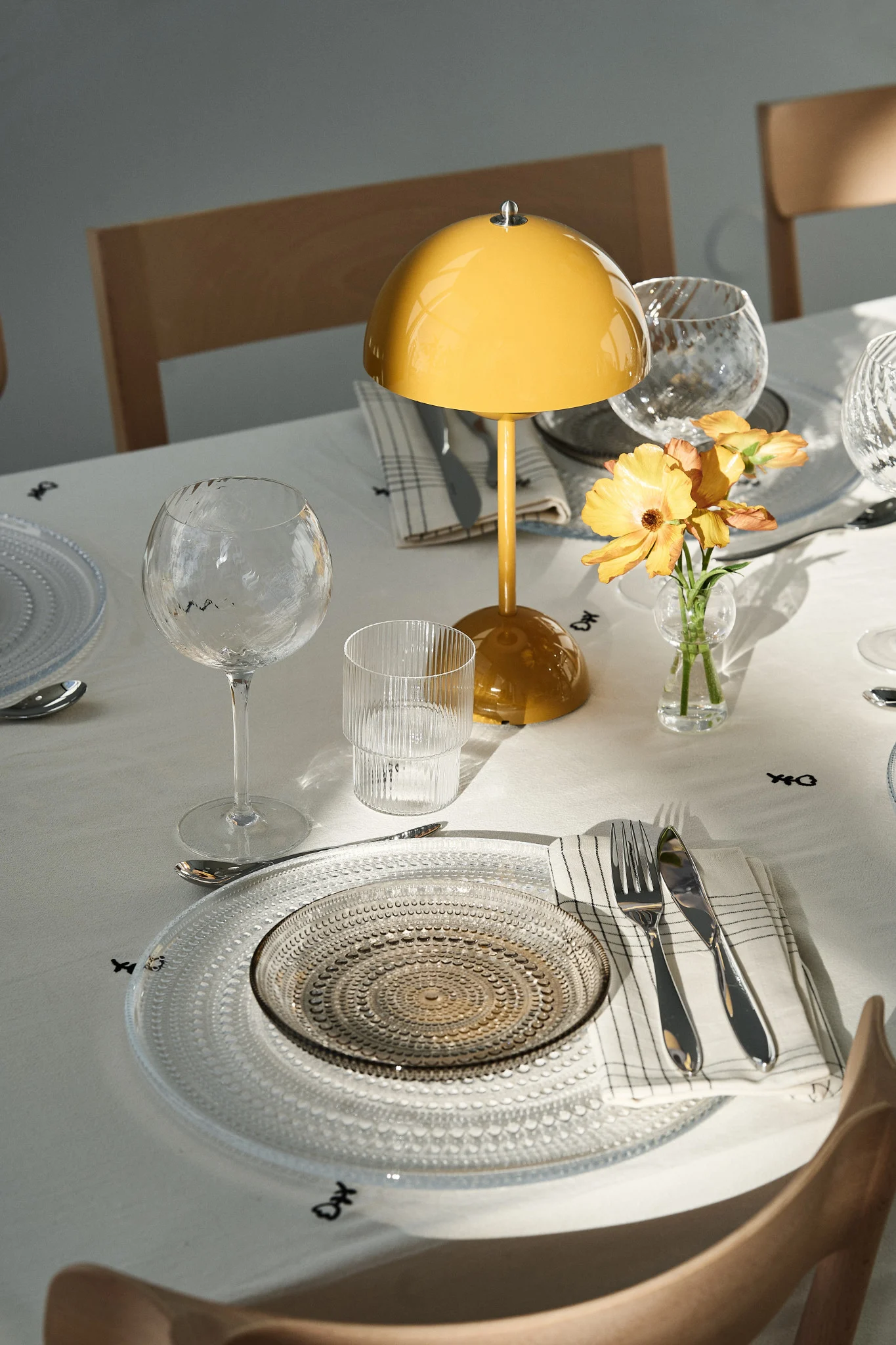 La table dressée est un élément essentiel de toute fête. Ici, vous voyez une décoration de fête avec une lampe portable Flowerpot et des assiettes en verre festives.