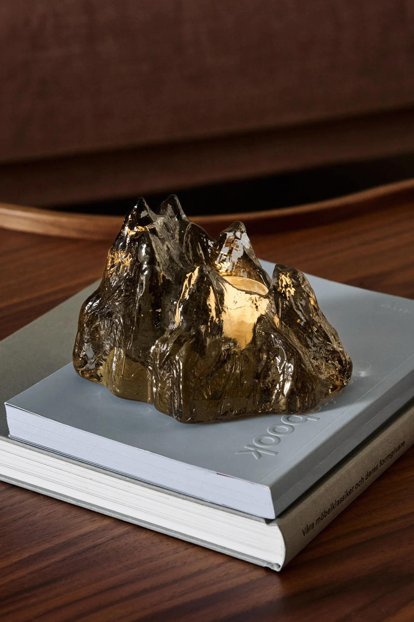 Sur un paquet de Nordic Nest, on voit le bougeoir marron The Rock de Kosta Boda sous le sapin.