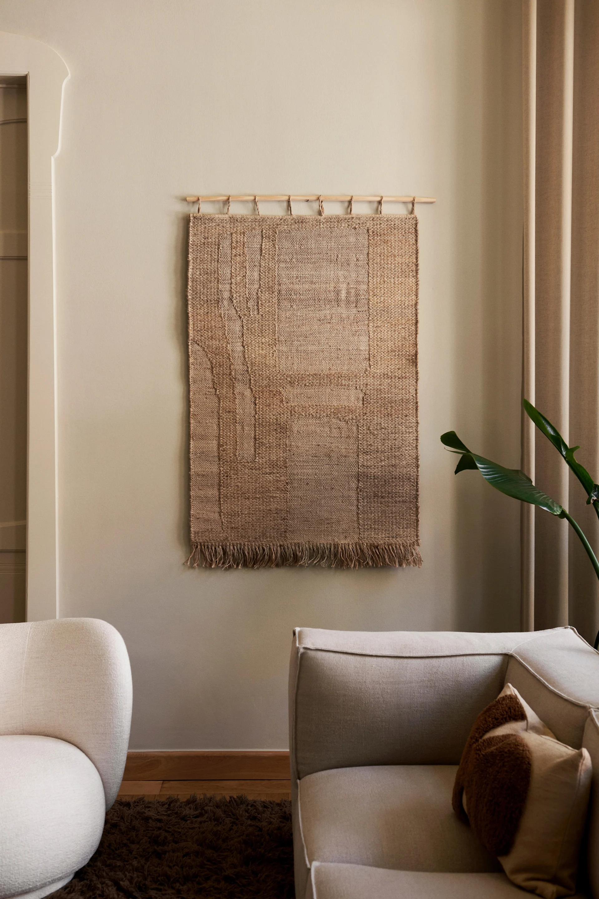 Décorez votre mur avec la décoration murale Harvest de Ferm Living, ici accrochée dans un salon sur un mur neutre. 