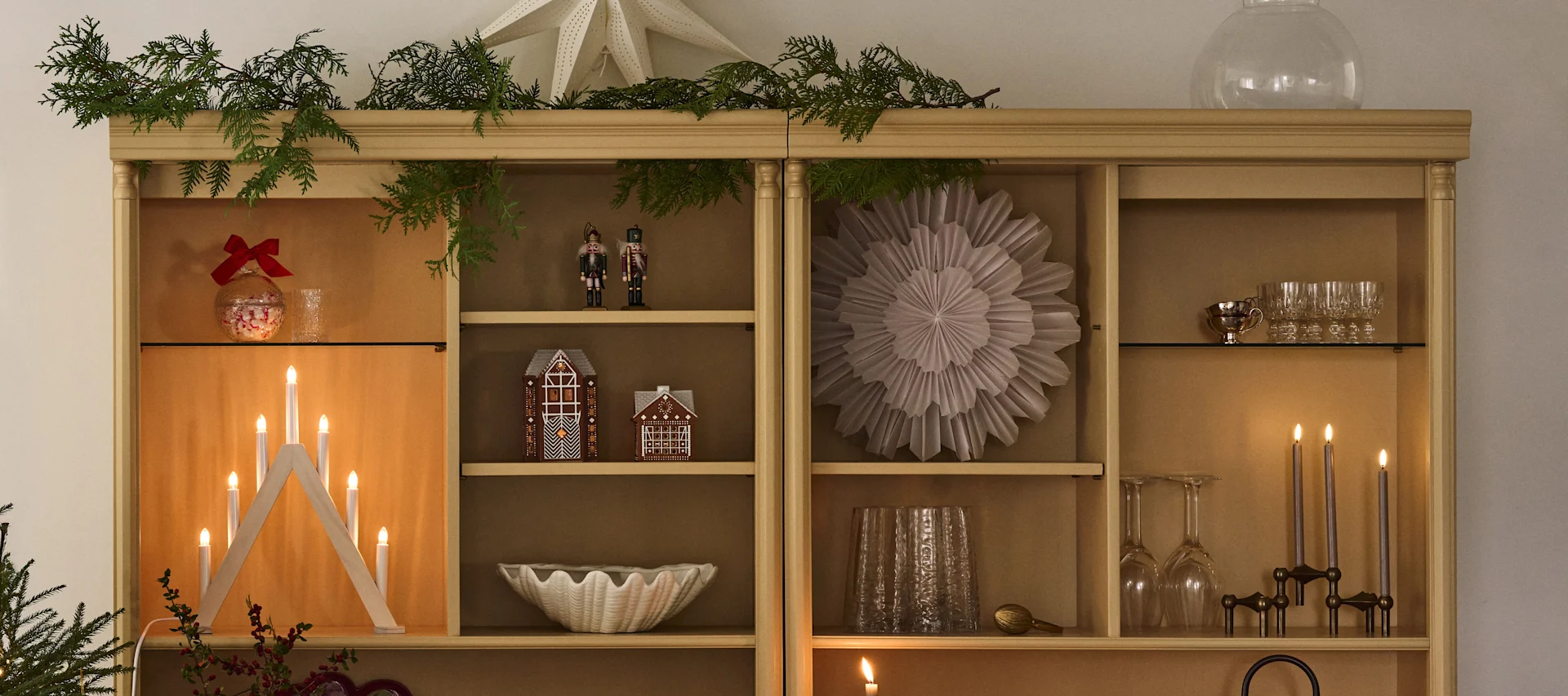 Une étagère décorée pour Noël avec des étoiles de Noël et des bougeoirs, parfaite pour se plonger dans l’ambiance du premier Avent.