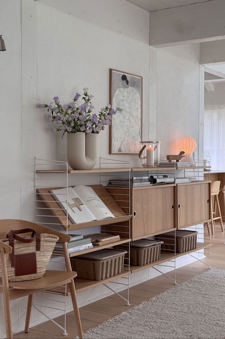 Tendances design de l'automne 2025 : Le système d'étagères String est flexible et peut être vu ici dans la maison de @zuhauselig, décoré avec des vases et des lampes de table.