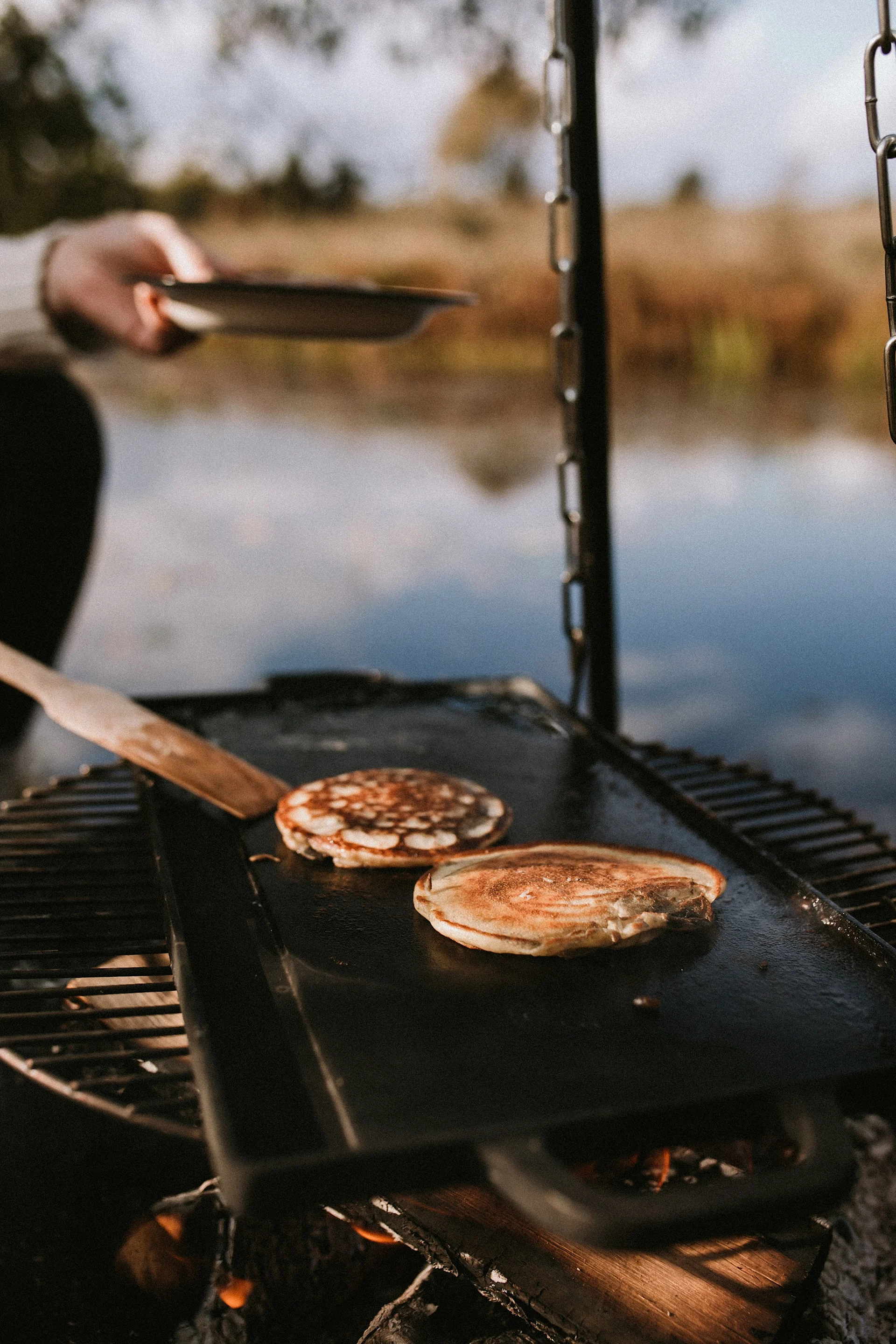 Cuisiner dehors dans le jardin est à la mode en 2025 - par exemple sur un feu ouvert, avec la table de cuisson Satake, sur laquelle sont cuites ici des crêpes.