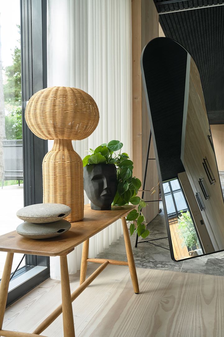 Les lampes de table en rotin sont idéales pour une décoration bohème. Ici, la lampe de table Vinka de Villa Collection est posée sur un petit banc décoratif en bois.