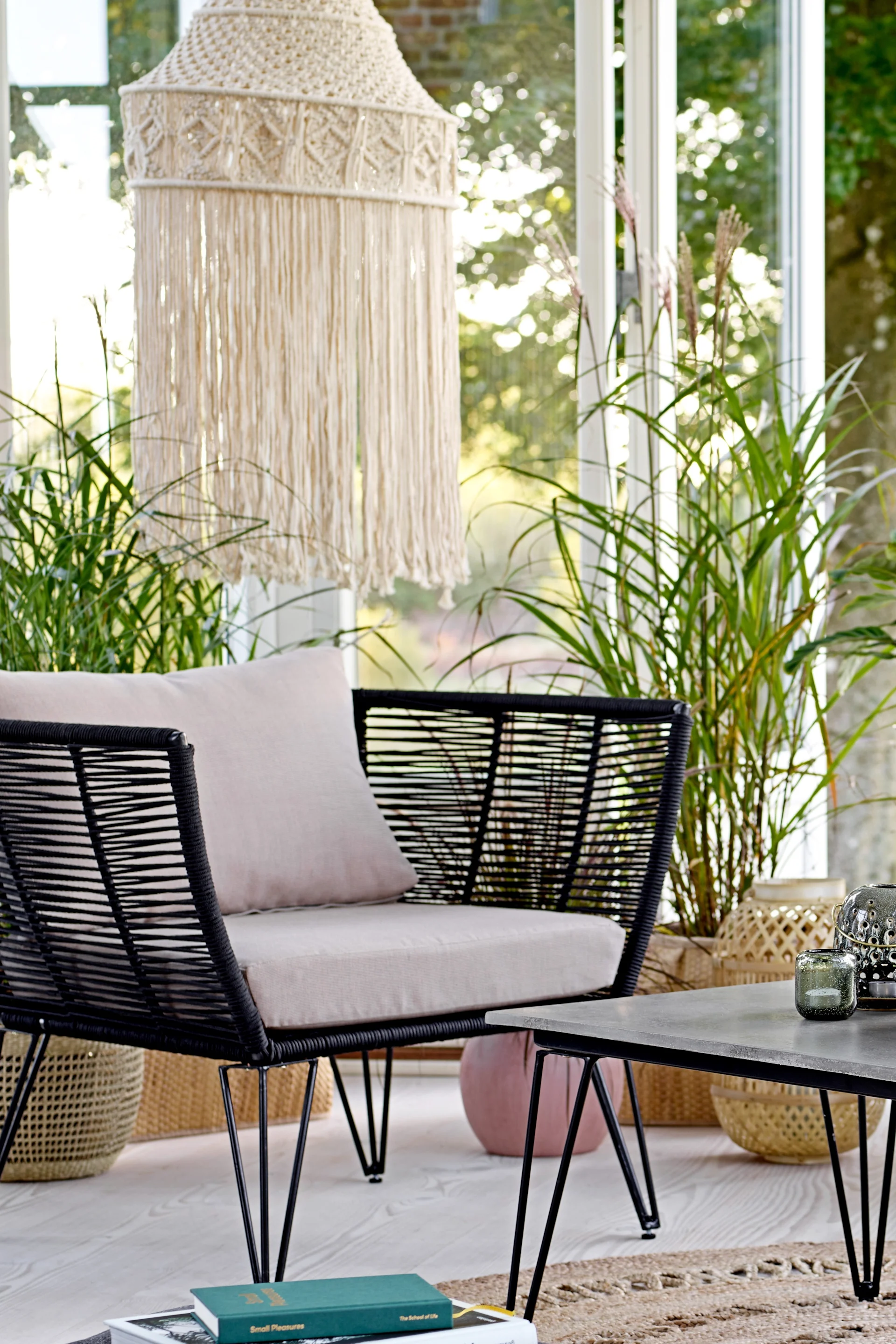 Le fauteuil lounge Mundo de Bloomingville correspond au style déco bohème typique et se trouve ici dans un espace lounge ouvert.