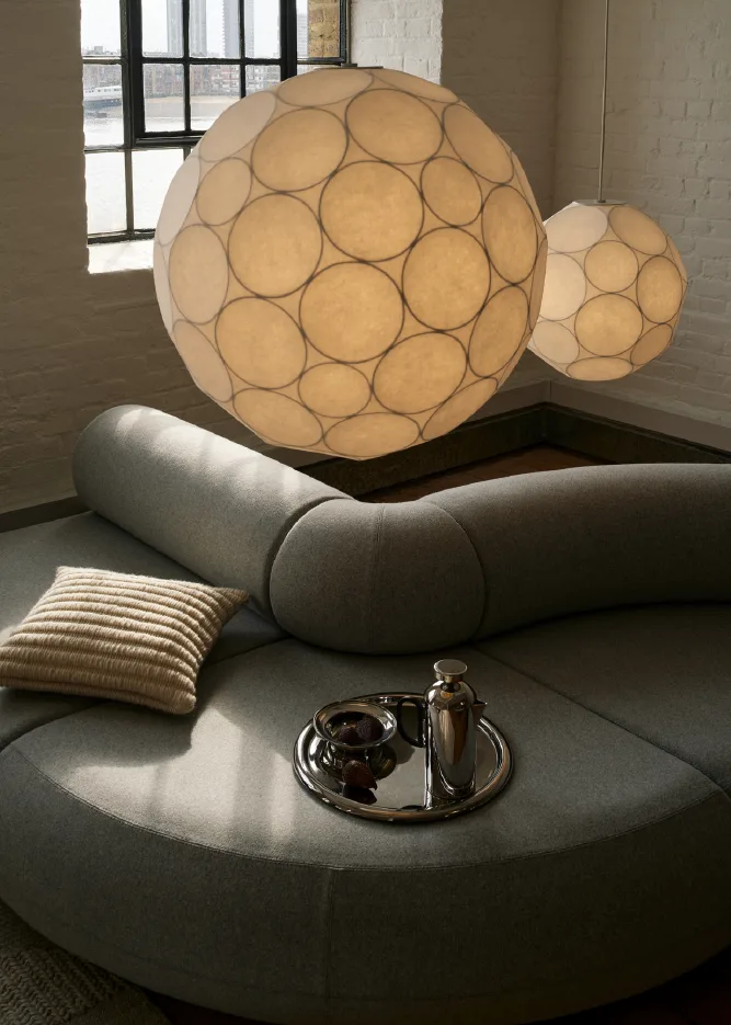 Les lampes avec abat-jour en papier sont l'une des tendances intérieures de l'automne 2025. Ici, plusieurs lampes suspendues Strand de Muuto sont accrochées au plafond.